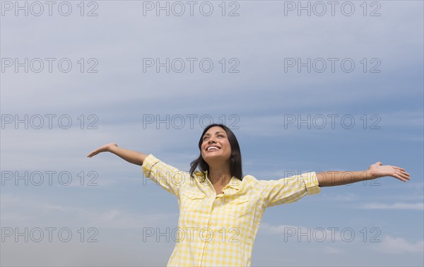 Happy woman against blue sky .