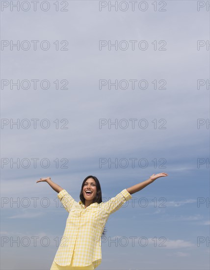 Happy woman against blue sky .