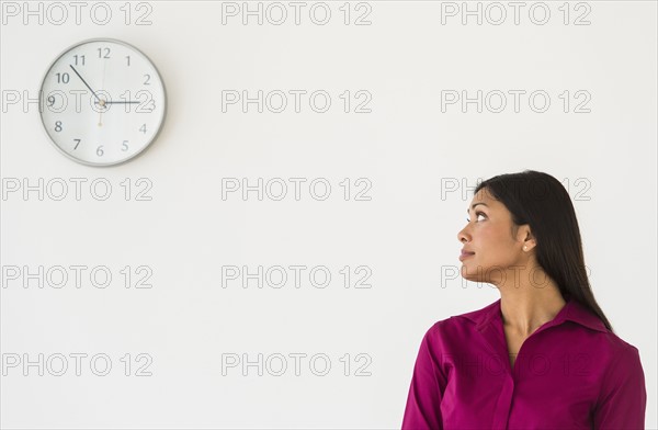 Woman looking at clock on wall.