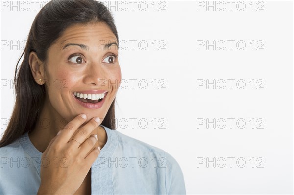 Studio shot of young woman smiling.