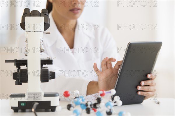Female scientist working on tablet PC .