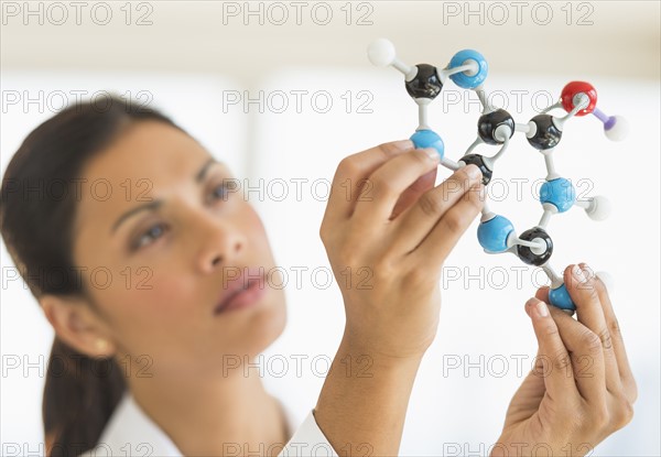 Female scientist holding molecule model.