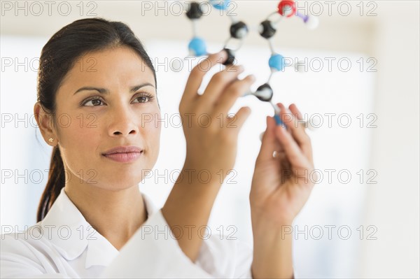 Female scientist holding molecule model.