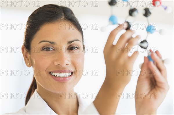 Female scientist holding molecule model.