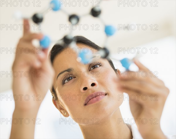 Female scientist holding molecule model.