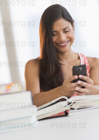 Woman text messaging while studying.