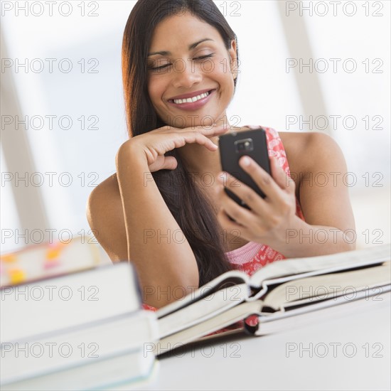 Woman text messaging while studying.