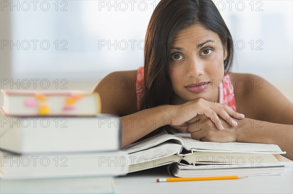 Female student leaning on books.