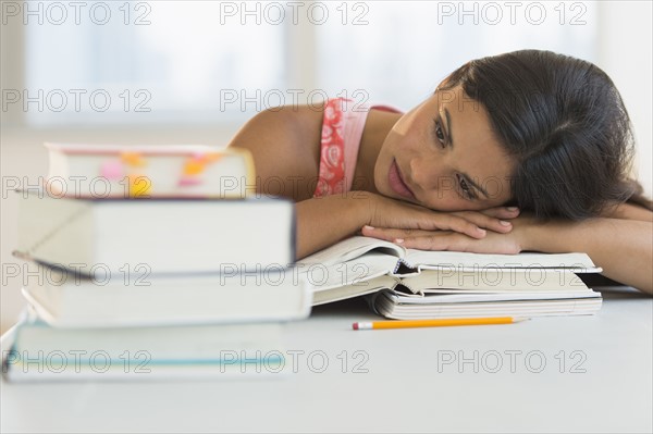 Female student leaning on books.