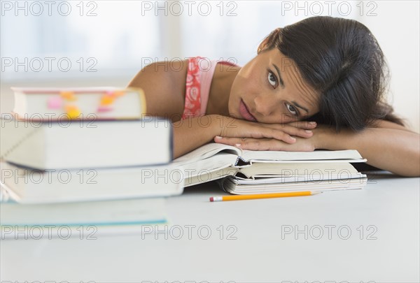 Female student leaning on books.