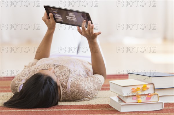 Woman lying on floor and using tablet PC.