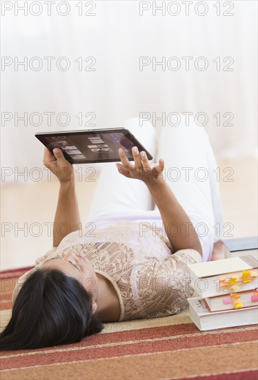 Woman lying on floor and using tablet PC.