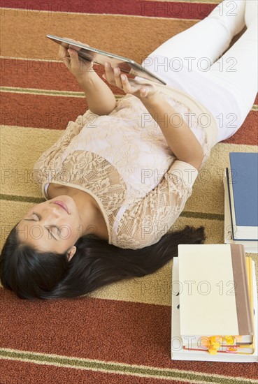 Woman lying on floor and using tablet PC.