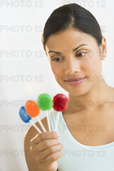 Woman holding colorful lollypops.