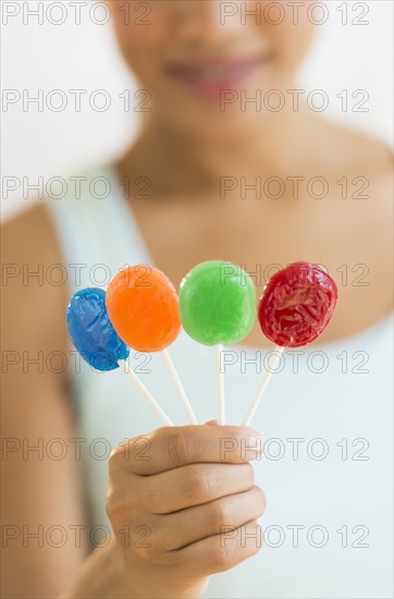 Woman holding colorful lollypops.