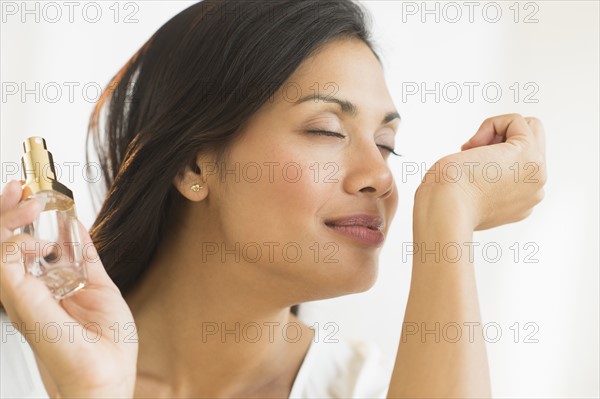 Woman smelling perfume on wrist.