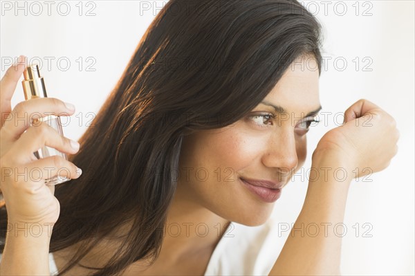 Woman smelling perfume on wrist.