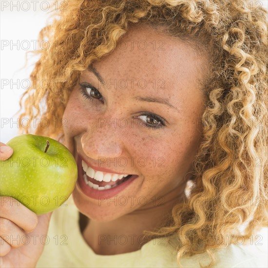 Portrait of smiling young woman with apple.