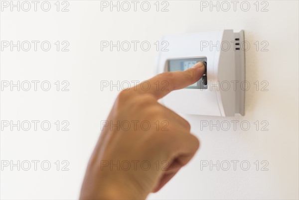 Young woman setting air conditioning.