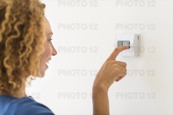 Young woman setting air conditioning.