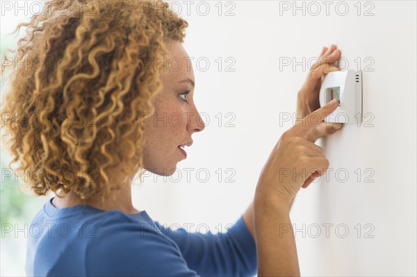 Young woman setting air conditioning.