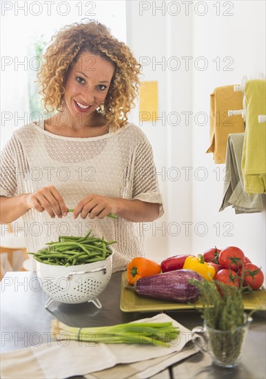 Young woman preparing food in kitchen.