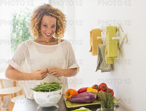 Young woman preparing food in kitchen.