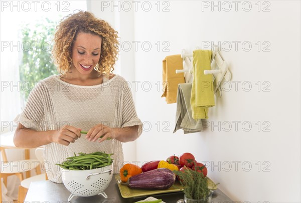 Young woman preparing food in kitchen.