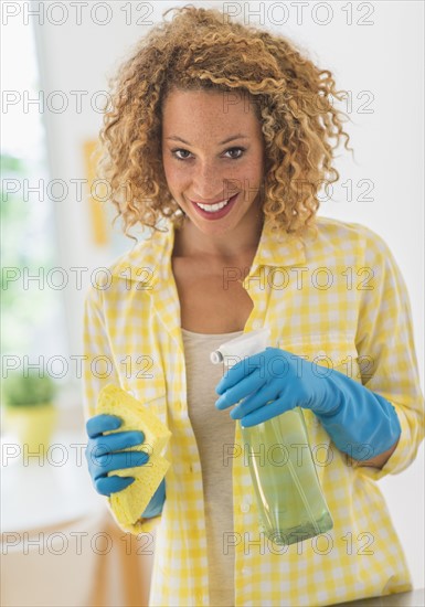 Young woman cleaning in kitchen.
