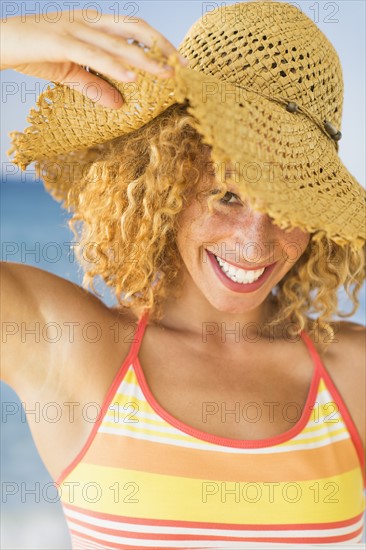 Portrait of smiling young woman in sun hat.