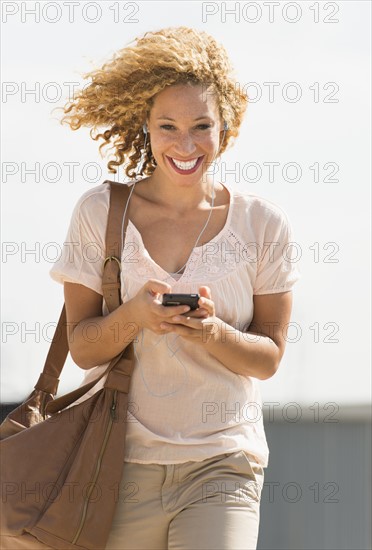 Young woman walking with headphones.