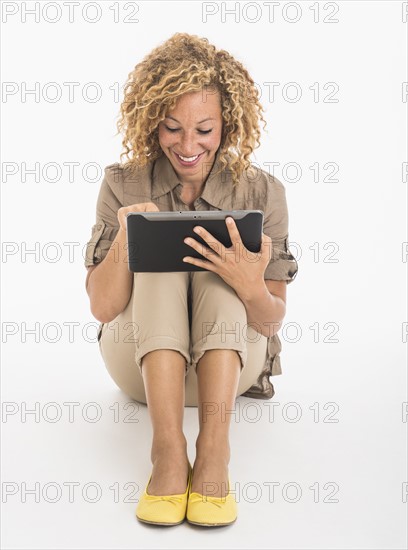 Portrait of young woman using digital tablet, studio shot.