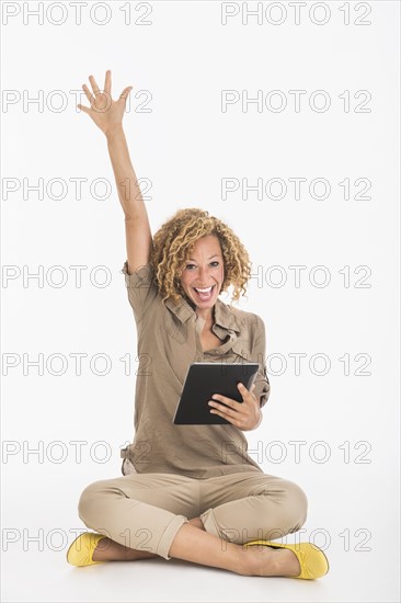 Portrait of happy young woman using digital tablet, studio shot.