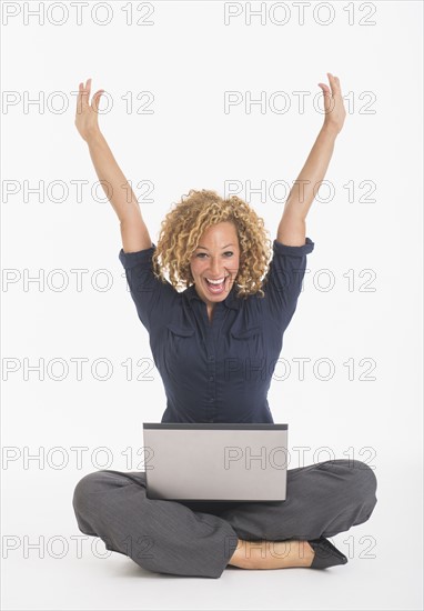 Portrait of happy young woman with laptop, studio shot.