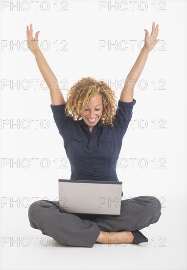 Portrait of happy young woman with laptop, studio shot.
