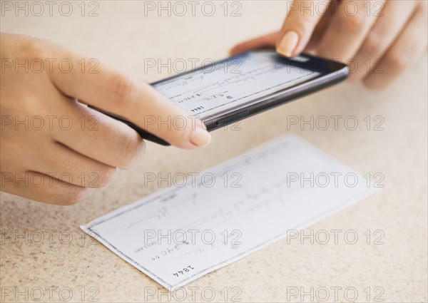 Close up of woman's hand doing online banking with mobile phone.