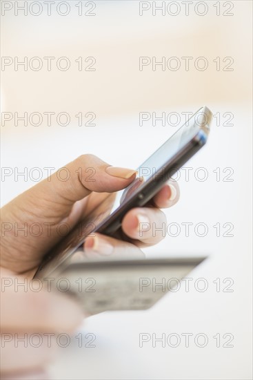 Close up of woman's hand doing online banking with mobile phone.