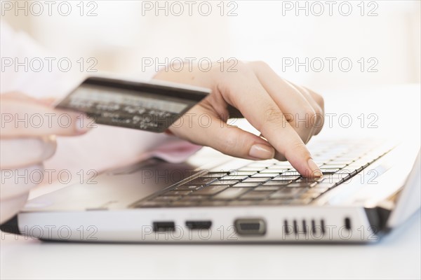Close up of woman's hand doing online banking with laptop.