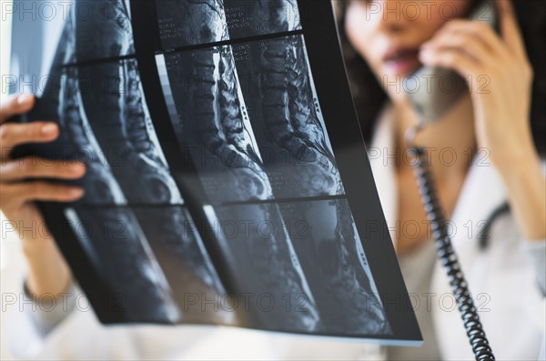 Female radiologist consulting MRI scan.