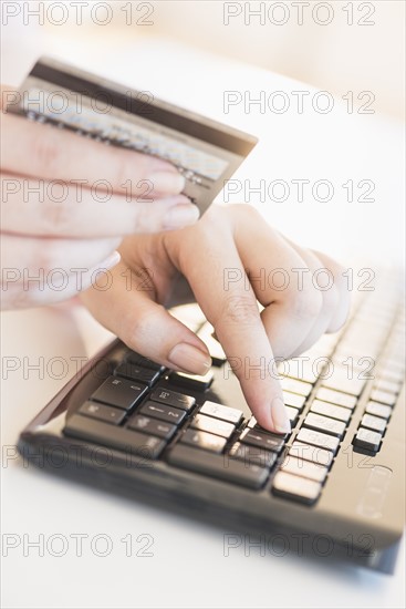 Close up of woman's hand doing online banking with laptop.