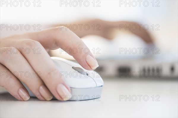 Close up of woman's hands using computer mouse.