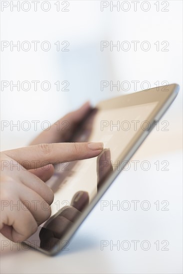 Close up of woman's hands using digital tablet.