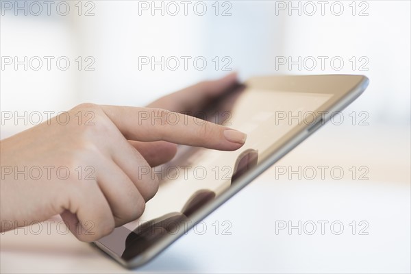 Close up of woman's hands using digital tablet.