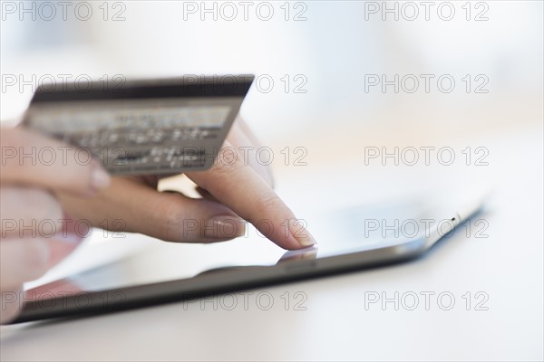 Close up of woman's hand doing online banking with laptop.