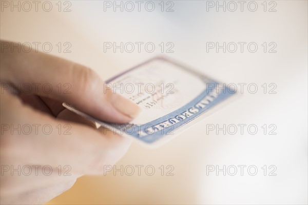 Close up of woman's hand holding social security card.
