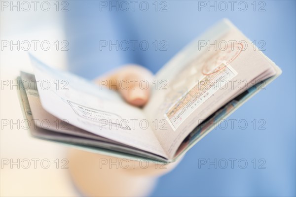 Close up of woman's hand holding open passport.