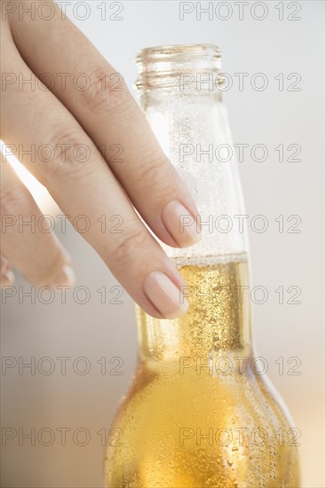 Woman holding beer bottle.