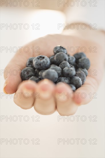 Blueberries on woman's hand.