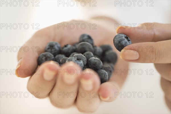 Blueberries on woman's hand.