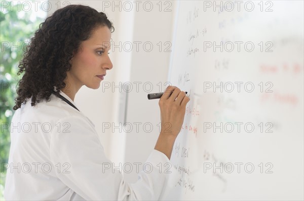 Doctor writing on whiteboard.